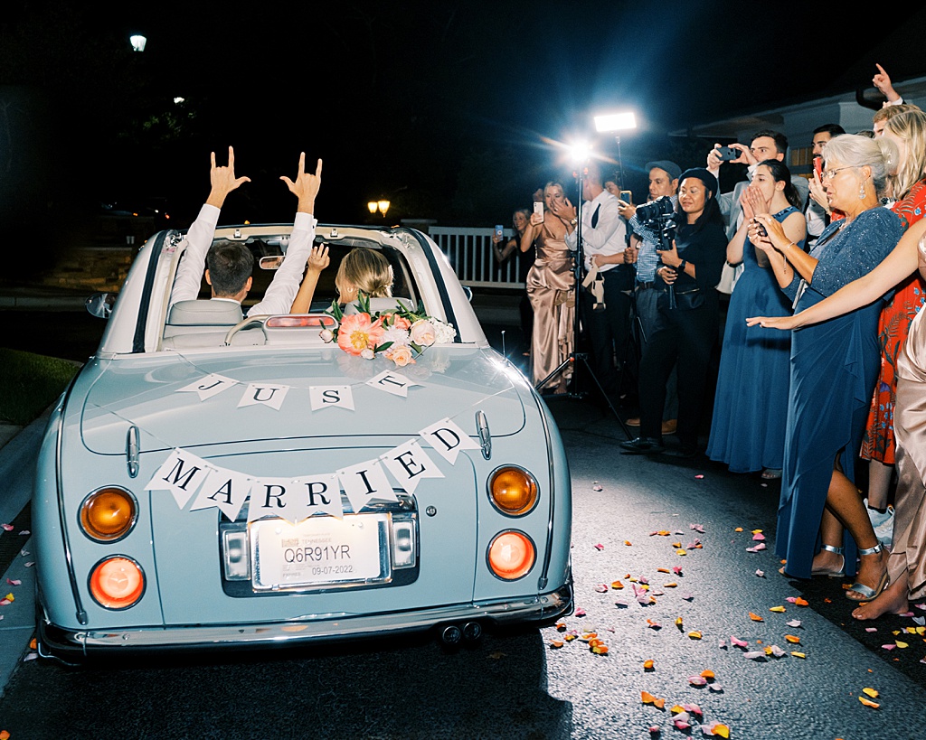 The bride in groom in their get away car after leaving their wedding. 
