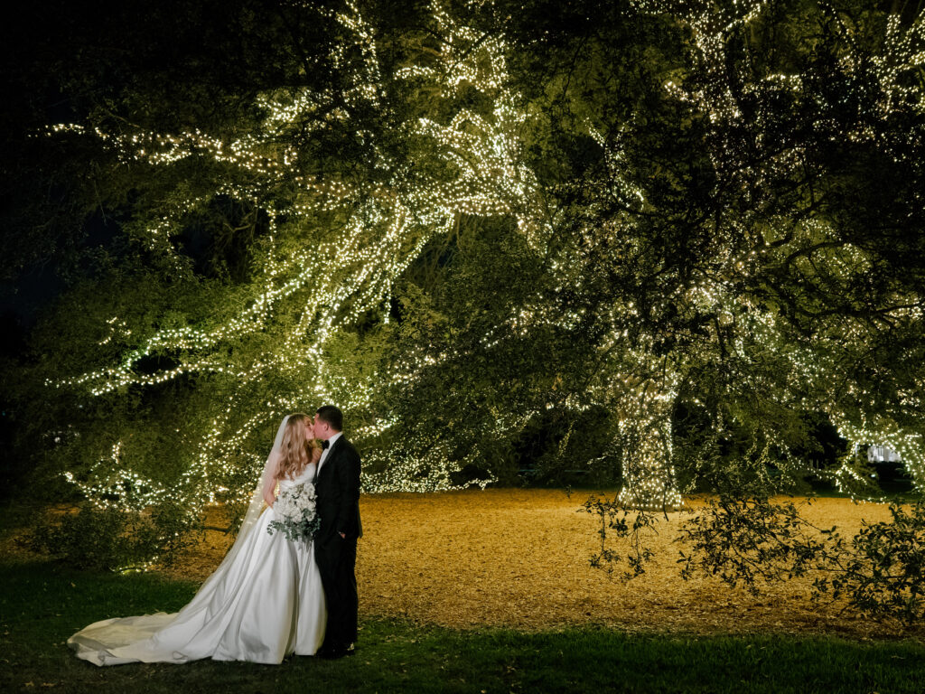 Couple poses under oak tree at Houstonian Club