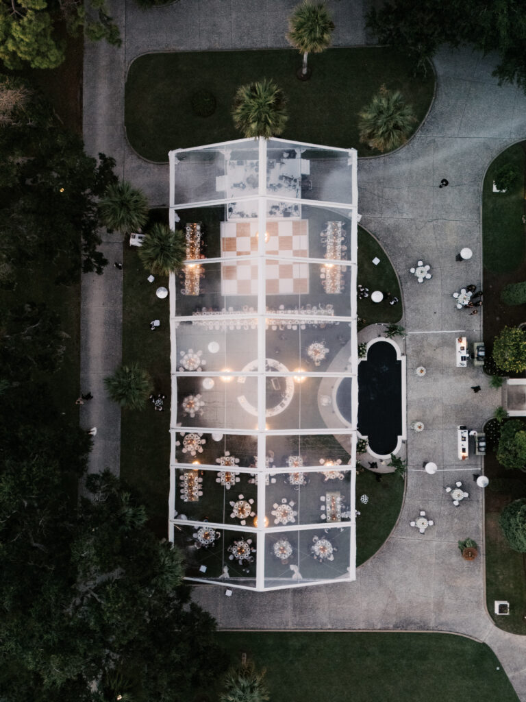 Drone overhead shot of tented reception area at sunset.