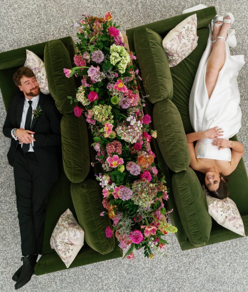 Aerial drone shot of a couple posing on a couch on their wedding day at the Gibbes Museum. 